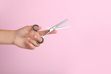 Hairdresser Holding Professional Thinning Scissors And Space For Text On Pink Background, Closeup. Haircut Tool