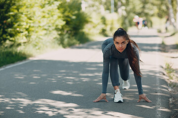 Athletic woman on track starting to run. Jogging pretty girl.