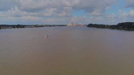 Sticker - A beautiful shot of calm river water flowing along the urban area under a cloudy sky in 4K