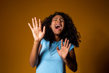 Angry young woman victim of domestic violence and abuse having nervous breakdown screaming. Black woman screaming victim of racism