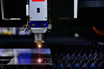 Wall Mural - industrial laser cut machine while cutting the sheet metal with the sparking light. free space on ri