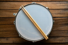 Drum Stick And Drum On Wooden Table Background, Top View, Music Concept