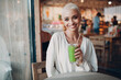 © primipil - Portrait of young smiling millenial european short haired woman with green smoothie at cafe. Beautiful happy blonde girl indoor.