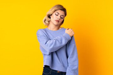 Wall Mural - Young Russian woman isolated on yellow background suffering from pain in shoulder for having made an effort