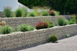 Geneigtes Wohngrundstück, neu terrassiert mit Stahlgitter-Gabionen mit Natursteinfüllung und initiale Hinterpflanzung mit Gartenpflanzen