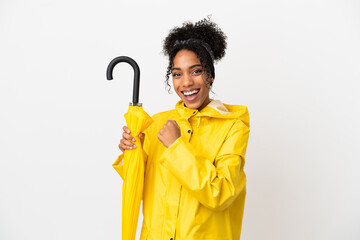 Canvas Print - Young woman with rainproof coat and umbrella isolated on white background celebrating a victory