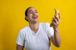 latin woman with banana in hand laughing out loud, on yellow background