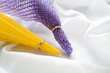 Yellow and purple mesh fabric is threaded through two gold wedding rings.