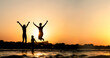 © Ermolaev Alexandr - Happy family is having fun and jumps at sunset beach in sunlight
