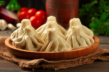 Wall Mural - Traditional Georgian dish, khinkali Kalakuri, on a wooden table, rustic, top view, no people, toned, 