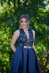 Poster - Shallow focus vertical shot of a young woman posing outdoors in a blue dress