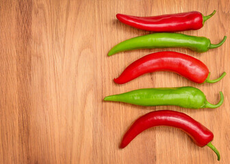  Red and green hot chili peppers on wooden background