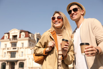 Sticker - Happy couple with coffee on city street in morning