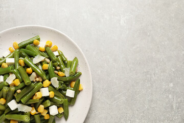 Wall Mural - Delicious salad with green beans, corn and cheese on light table, top view. Space for text