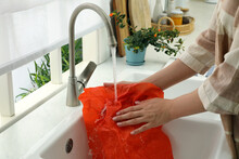 Woman Washing Beeswax Food Wrap Under Tap Water In Kitchen Sink, Closeup
