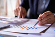 © crizzystudio - Accountant or banker working process, a Businesswoman using a calculator to calculate the numbers of statistic business profits growth rate on documents graph data, his desk in an office.