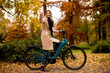 © BGStock72 - Young woman with electric bicycle in te autumn park