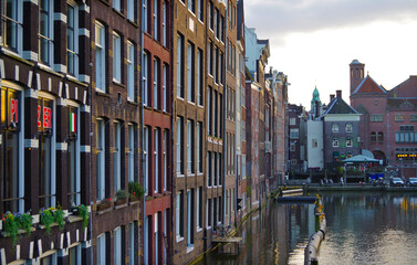 Amsterdam Netherlands dancing houses over river Amstel landmark besides Grachten canals with city skyline old town historic architecture Delft style