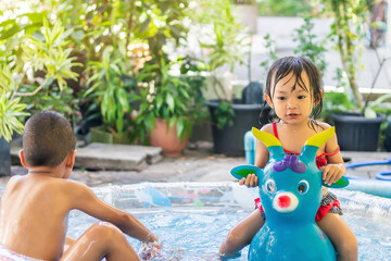 In the Summer season. Asian children swimming and playing in the the water pool.