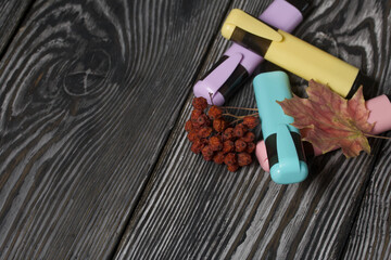 A set of colored markers for the school. They lie on pine boards. Nearby autumn maple leaves.