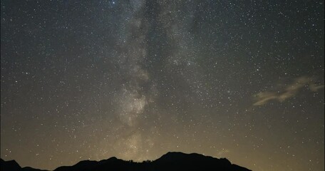 night time lapse of the milky way galaxy and stars moving over the alps in slovenia. silhouette of m