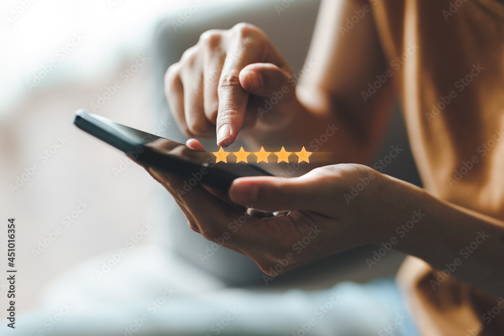 Close up of woman customer giving a five star rating on smartphone. Review, Service rating, satisfaction, Customer service experience and satisfaction survey concept.. - obrazy, fototapety, plakaty 