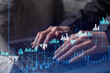 © VideoFlow - Woman typing the keyboard to research stock market to proceed right investment solutions. Internet trading and wealth management concept. Formal wear. Hologram Forex chart over close up shot.