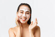 Skincare, women beauty, hygiene and personal care concept. Close-up of happy smiling asian woman standing naked in bath, using daily-care skin cleansing foam and looking delighted, white background