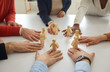 Leinwandbild Motiv Group of multiracial business people working together arrange human figures in circle on table. Team of multiethnic workmates join little wooden figures as teamwork, community and collaboration symbol