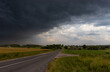 A large dark thundercloud over the road and the village 