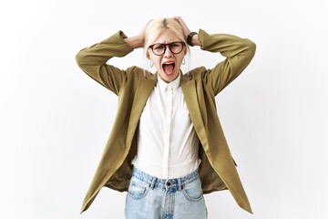 Wall Mural - Beautiful caucasian business woman standing over isolated background crazy and scared with hands on head, afraid and surprised of shock with open mouth