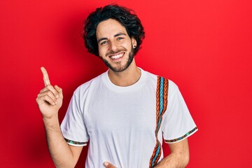 Sticker - Handsome hispanic man wearing casual white t shirt smiling happy pointing with hand and finger to the side