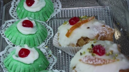 Poster - A video catching focus on different variety of delicious pastry with white cream decorated with sugar powder and cherry