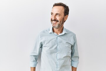 Sticker - Middle age hispanic man with beard standing over isolated background smiling looking to the side and staring away thinking.