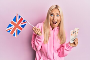 Poster - Young blonde woman holding united kingdom flag celebrating crazy and amazed for success with open eyes screaming excited.