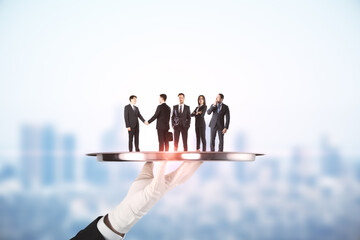 Poster - Hand holding silver tray with businesspeople on abstract blurry city background. Team work and service concept.