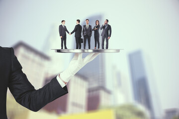 Poster - Hand holding silver tray with businessmen and women on abstract blurry city background. Teamwork and service concept.