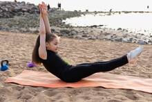 Girl Gymnast Trains On The Beach By The Sea. Photo Series