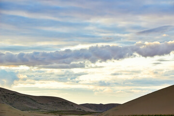 Wall Mural - Evening cloudy sky over the sand dunes.