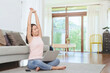 © interstid - Asian woman stretching her arms for relax after working at home via laptop in living room at home