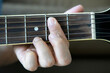 © PILYONG - hand holding guitar chord for playing