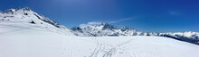 View On Peak Mountain Covered With Snow And Ski Tracts Under Blue Sky In Alps