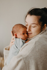 loving mother carying of her newborn baby at home. bright portrait of happy mum holding cute infant 