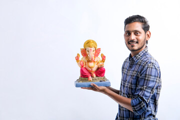 Celebrate ganesha festival.young indian handsome man with lord ganesha.