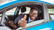 © Dragana Gordic - Handsome African American unshaven classy businessman in suit and with eyeglasses holding hand on steering wheel and giving thumbs up. Portrait of happy man showing thumbs up