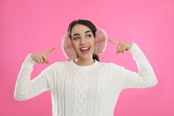 Canvas Print - Beautiful young woman wearing earmuffs on pink background