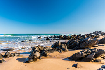 Waves rolling over rocks, along a sandy beach on the Fleurieu Peninsula, South Australia