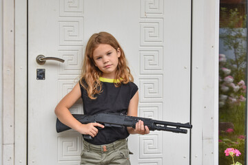 child girl with a rifle guards her own house photo without processing