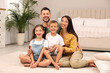 © New Africa - Portrait of happy family on floor in bedroom