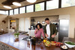 © Wavebreak Media - Happy diverse couple in kitchen preparing food together drinking wine